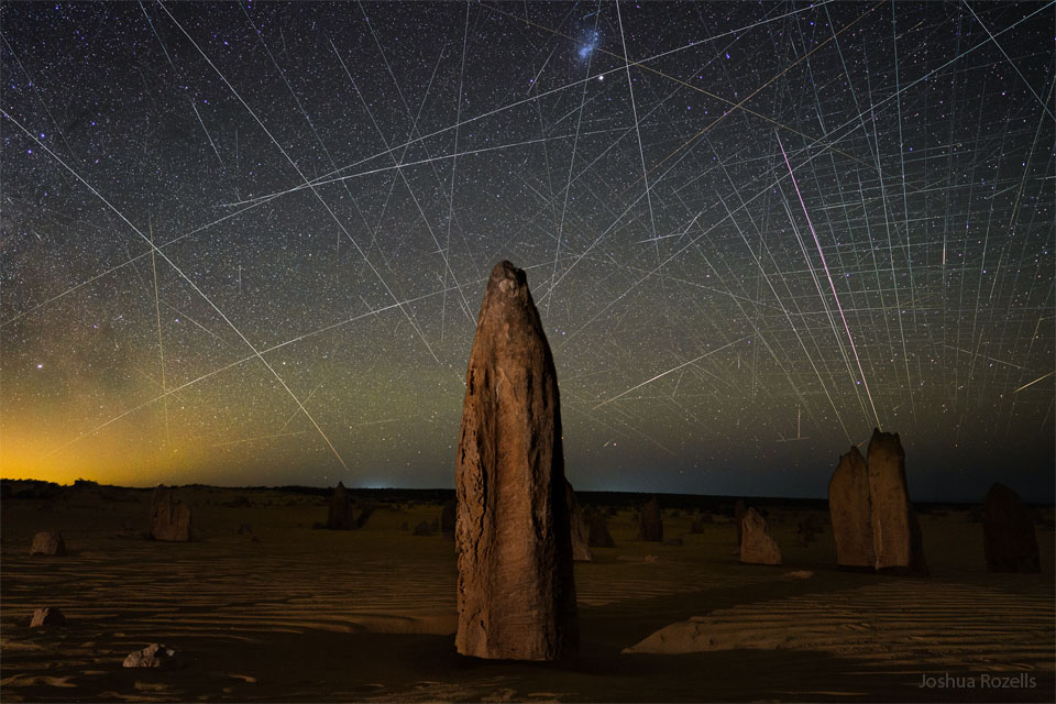 The featured image shows the rock spires known as 
Pinnacles that occur in Australia. Behind the spires is a
sky filled with satellite trails, including many from the
Starlink constellation of low-Earth orbit satellites.
Please see the explanation for more detailed information.